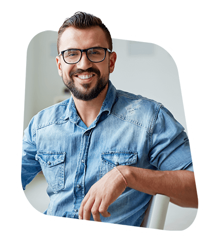 a man smiles while sitting on a chair