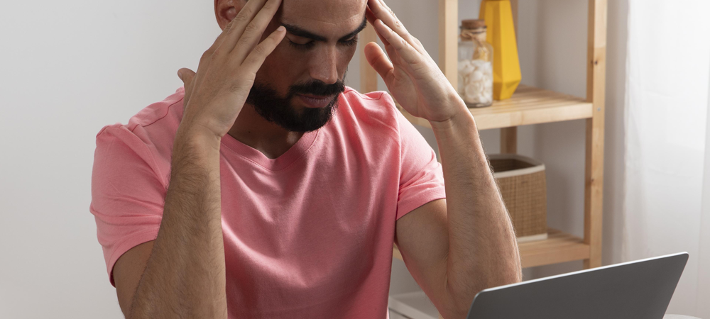 Frustrated man sitting at a laptop