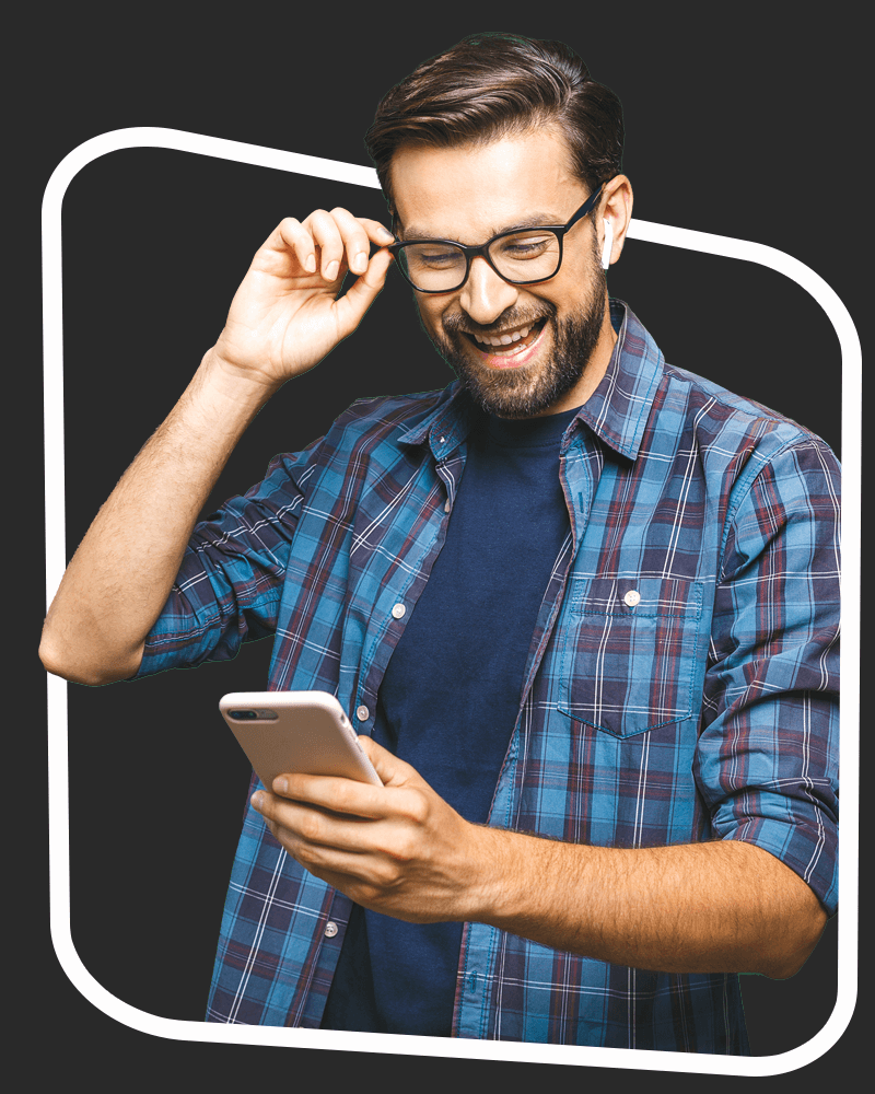 Man in a checked shirt looks at his mobile phone