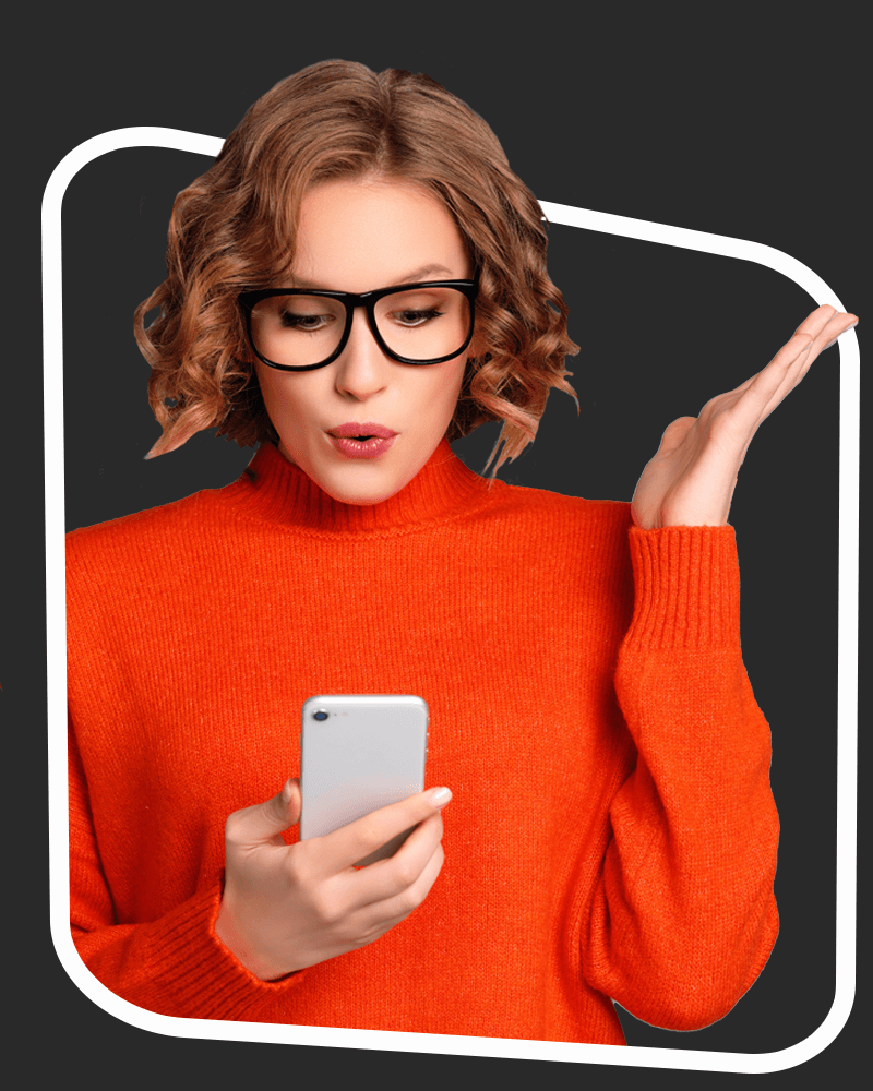 Woman in an orange jumper looks at phone